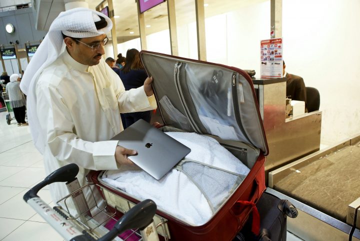 Ativista do Kuwait Thamer al-Dakheel Bourashed guarda o seu portátil na bagagem de porão