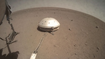 Imagem da Sonda Insight da NASA a destapar a "toupeira" no solo de Marte