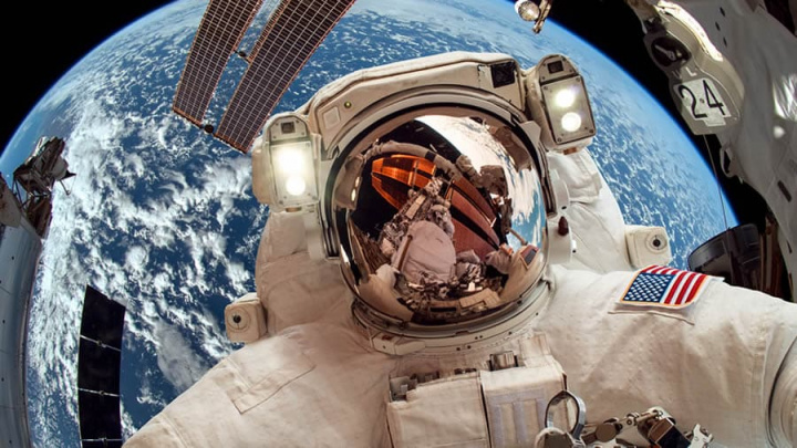 Imagem astronautas da NASA no espaço ao lado da ISS