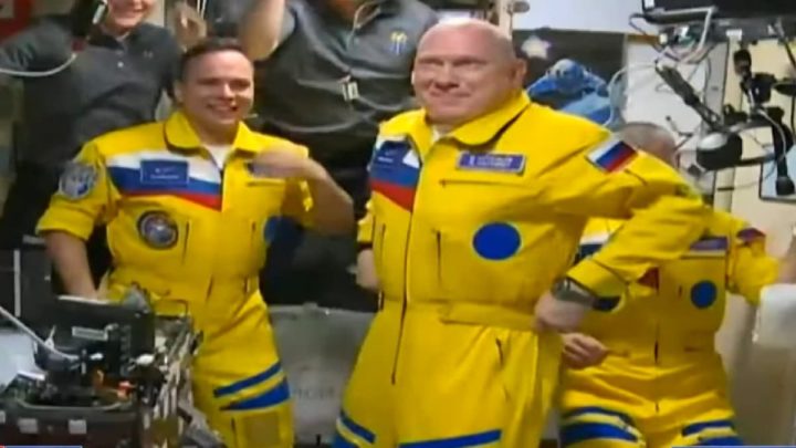 Imagem dos cosmonautas russos chegados à ISS vestidos de amarelo Ucrânia