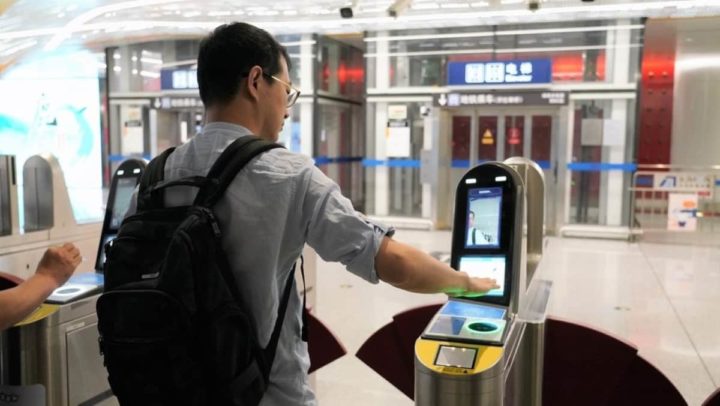 Passageiro usa palma da mão para entrar no metro, em Pequim, na China
