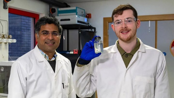 Cientista Sudhagar Pitchaimuthu (esquerda) e estudante de doutoramento Michael Walsh, com uma amostra de água residual de uma destilaria de whisky. Fonte: Universidade Heriot-Watt