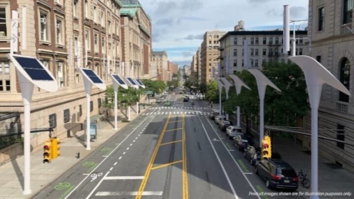 Carregadores de VE, que também sãi postes de iluminação pública, instalados numa avenida. Imagem representativa 