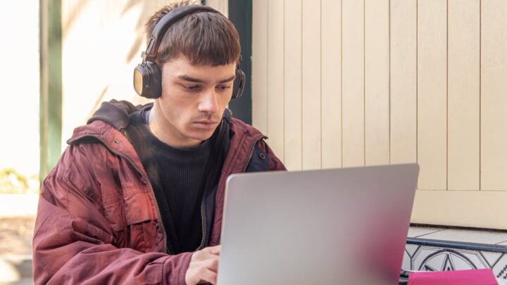 Estudante a usar um computador portátil com auscultadores