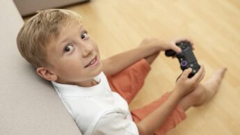 Criança com um comando de PlayStation