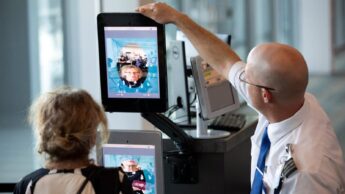 Segurança a recolher fotografia de uma passageira no aeroporto