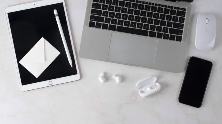 Dispositivos Apple espalhados numa mesa de trabalho