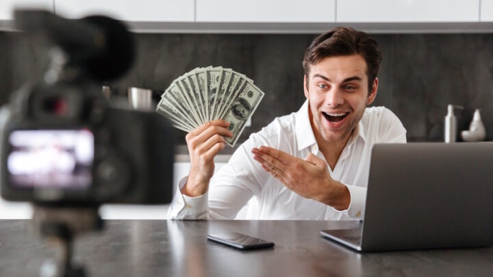 Homem a filmar-se com notas na mão