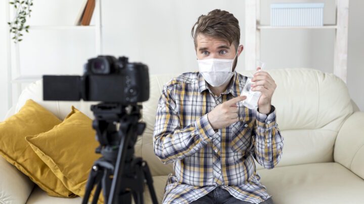 Homem com máscara a filmar-se a segurar um frasco de alcool 