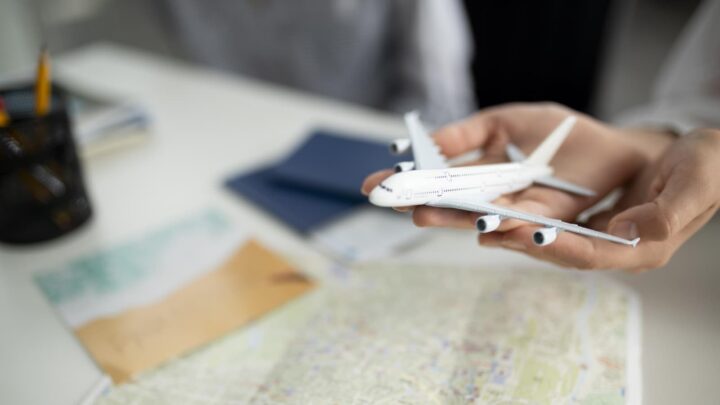 Avião de brinquedo a ser segurado por cima de um mapa