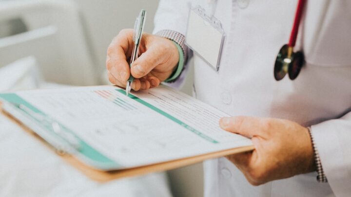 Médico a escrever uma receita, talvez de um exame