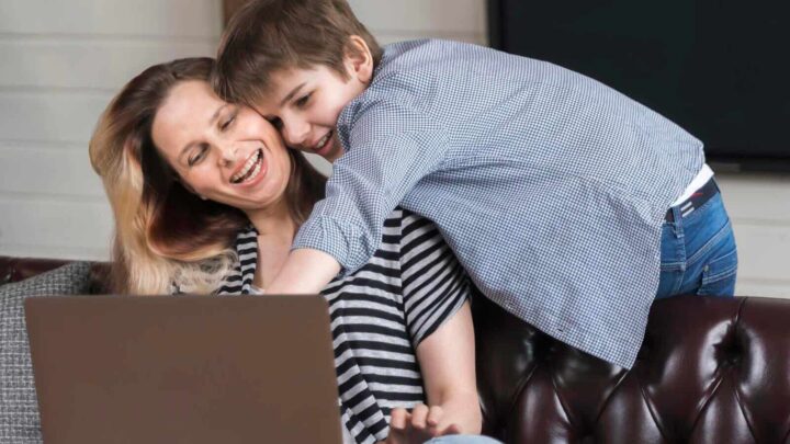 Criança com a mãe, em frente a um computador portátil